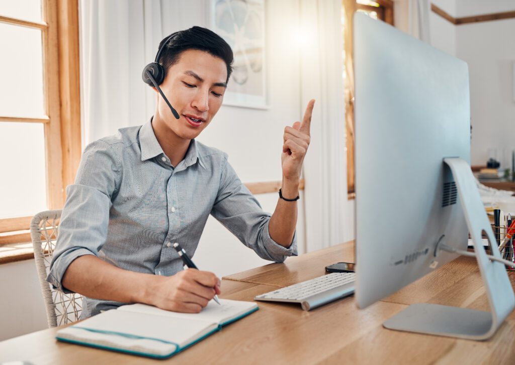 man at computer with VoIP headset on 