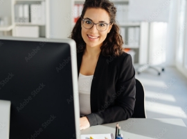 Young businesswoman sitting working at a desktop