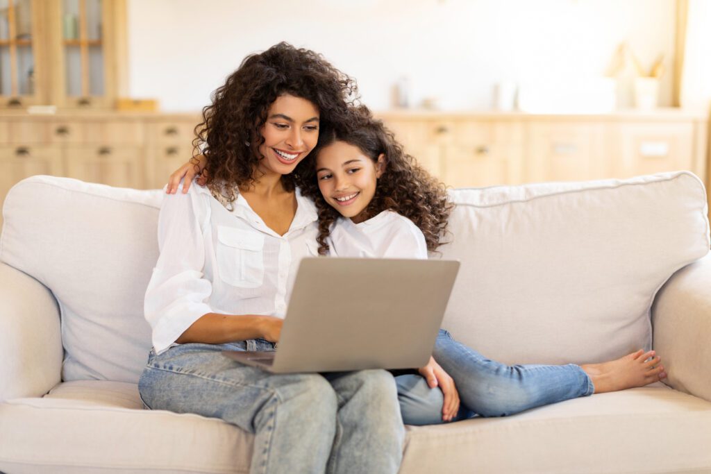 A mother and daughter on the couch browsing the internet